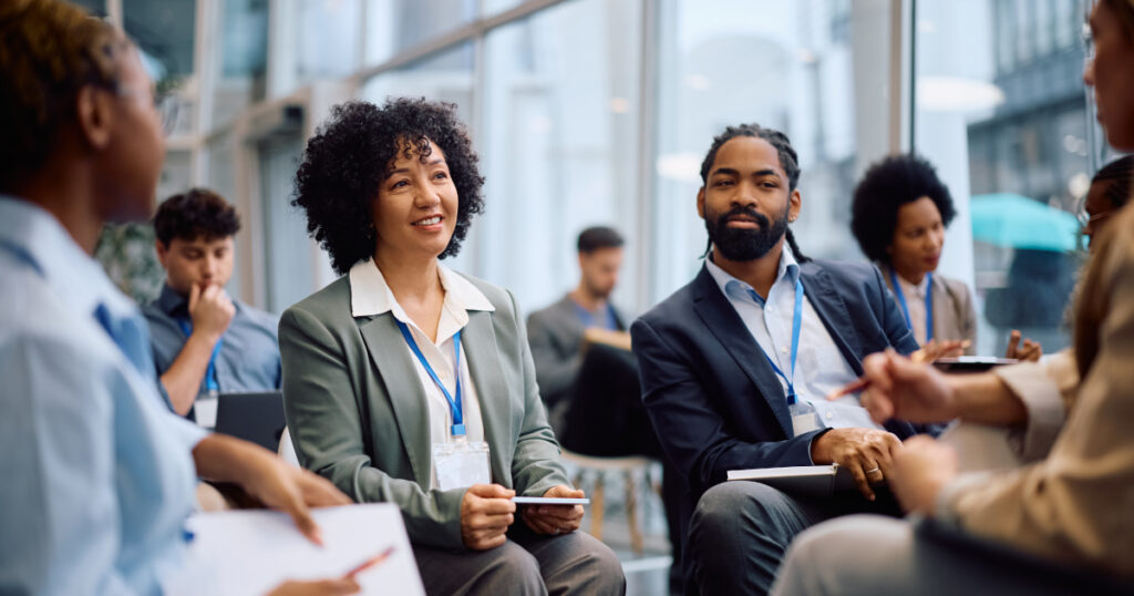 Delegates sitting together at a workshop talking and making notes